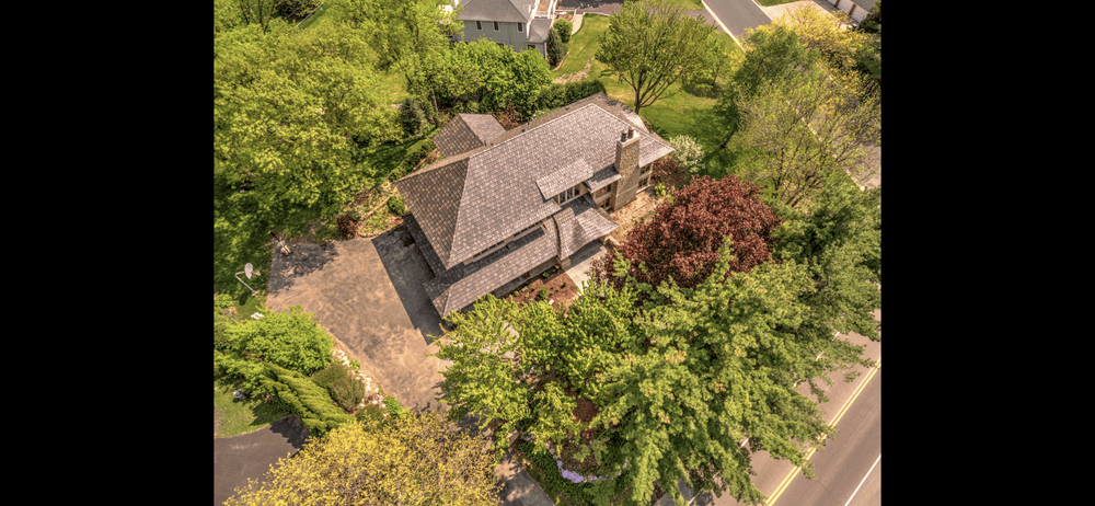 Aerial view of a landscaped home surrounded by greenery and trees.